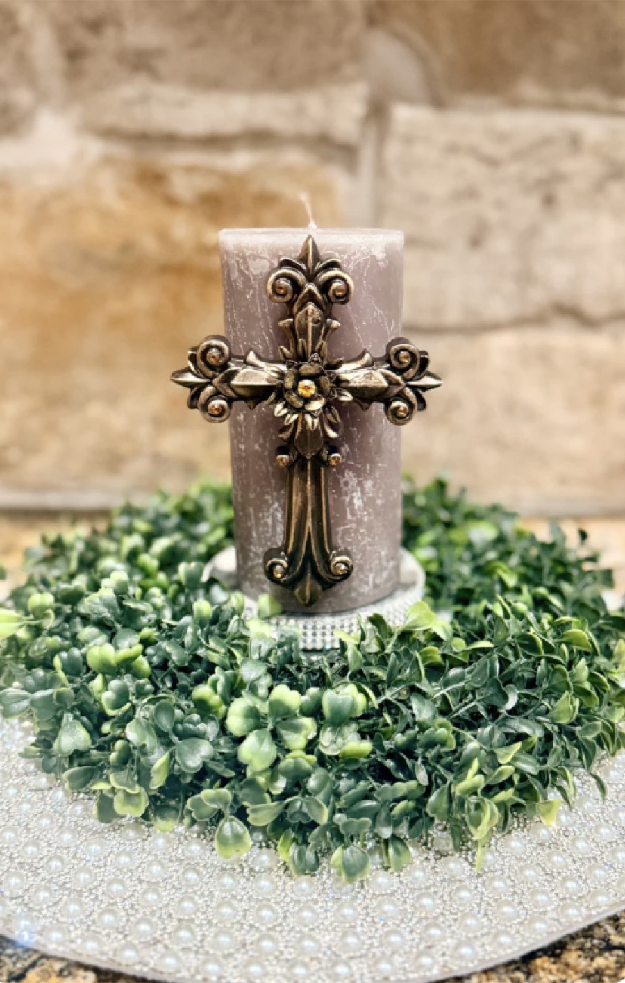 Mauve candle with an ornate bronze cross pin embellishment