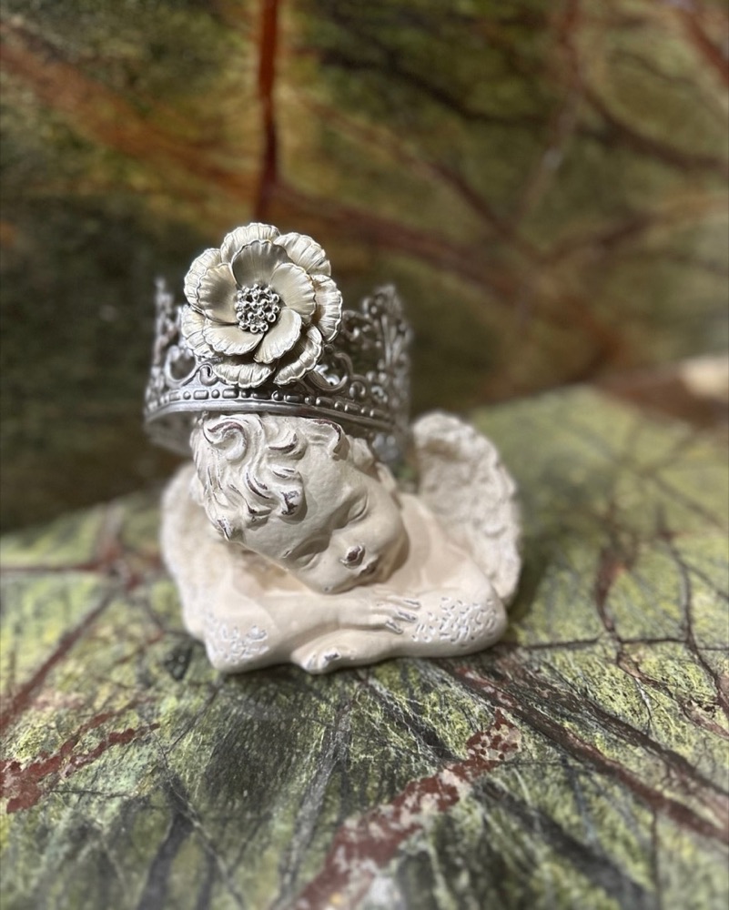 Sleeping cherub figurine wearing a silver flower crown