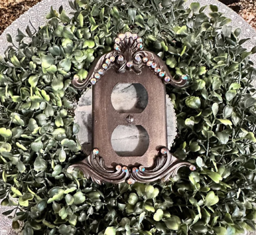 Ornate bronze outlet cover with rhinestone detailing